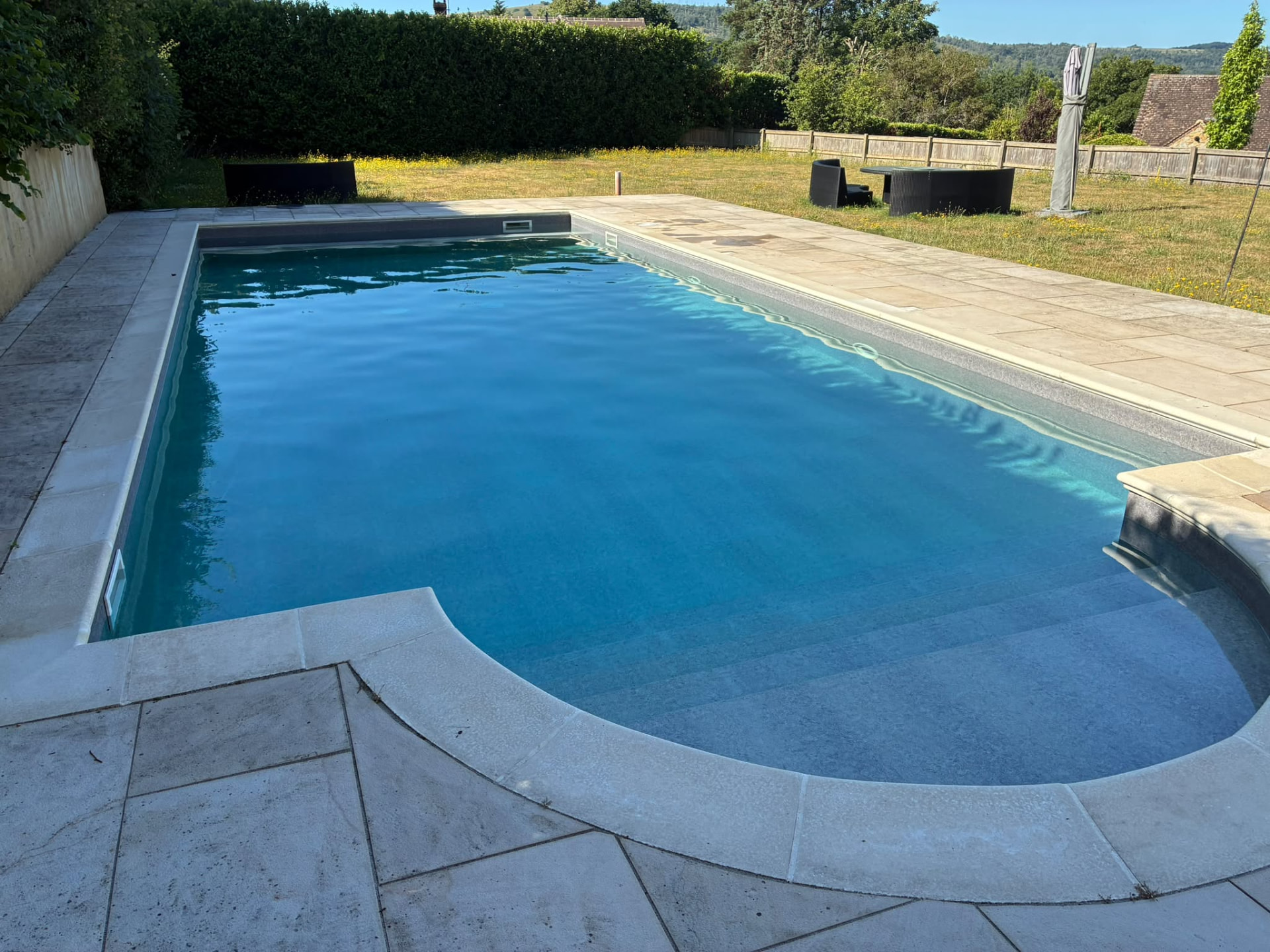 Refurbished garden swimming pool with curved Roman steps, new liner and stone coping