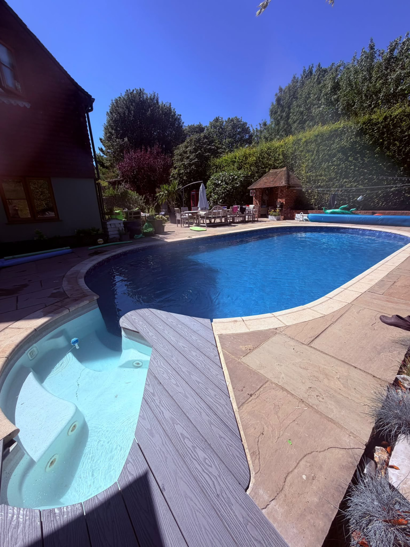 Garden swimming pool with curved steps, spa section and decking