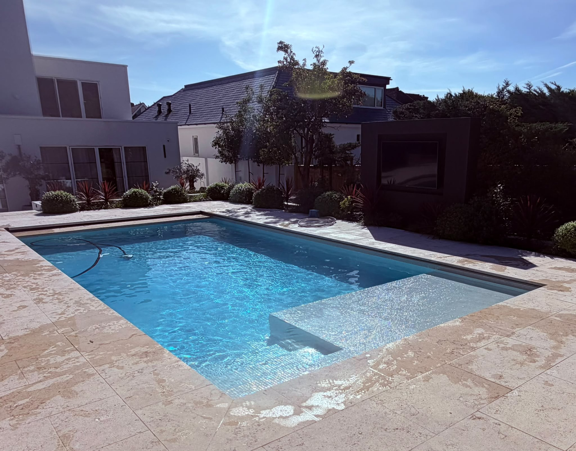 Sparkling clean garden swimming pool on a regular pool servicing plan