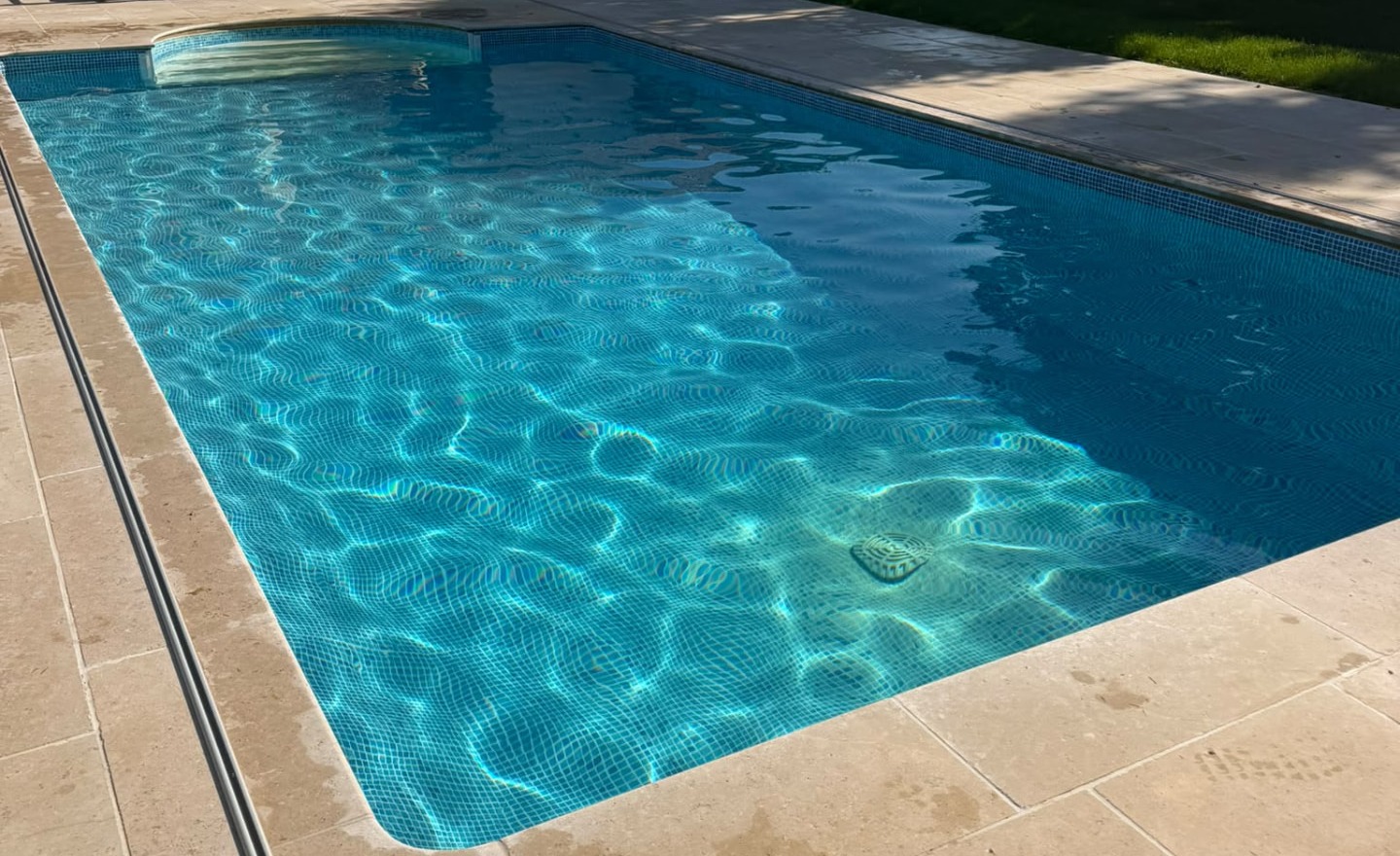 Sparkling blue tiled swimming pool in the sunshine, maintained by Baldwin's Pools